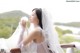 A woman in a wedding dress holding a white feather.