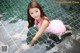 A woman in a pink dress is in a swimming pool.