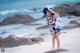 A woman in a sailor outfit standing on a beach.