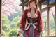 A woman in traditional attire stands outdoors with cherry blossoms and greenery in the background.