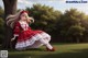 A girl in a red and white dress sitting under a tree.