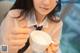 A woman holding a cup of milk with a spoon in it.