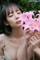 A woman holding a bunch of pink flowers in her hand.